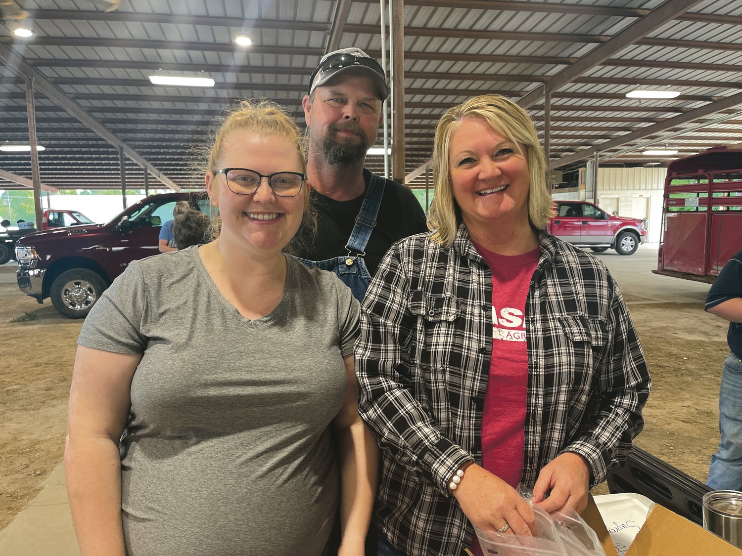 Fair Board President Glenn Raef (center), his wife Jennifer (right) and their daughter Baleigh Bilger (left) are pictured at the market animal weigh-in on Saturday, May 14.